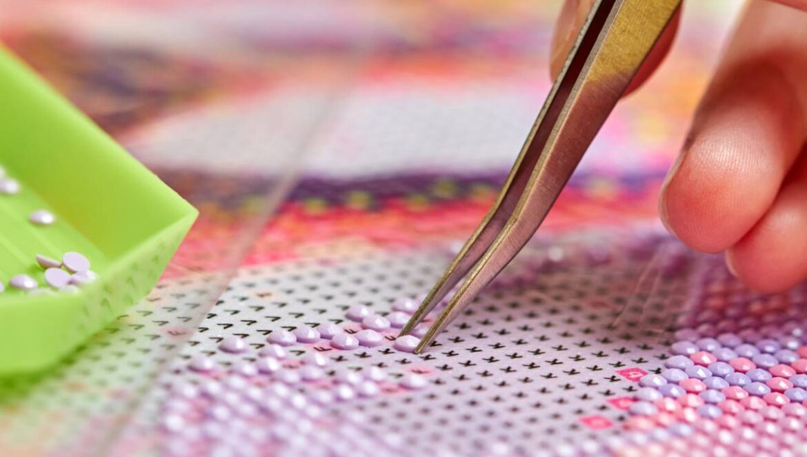 Pose des strass colorés sur une toile de diamond painting