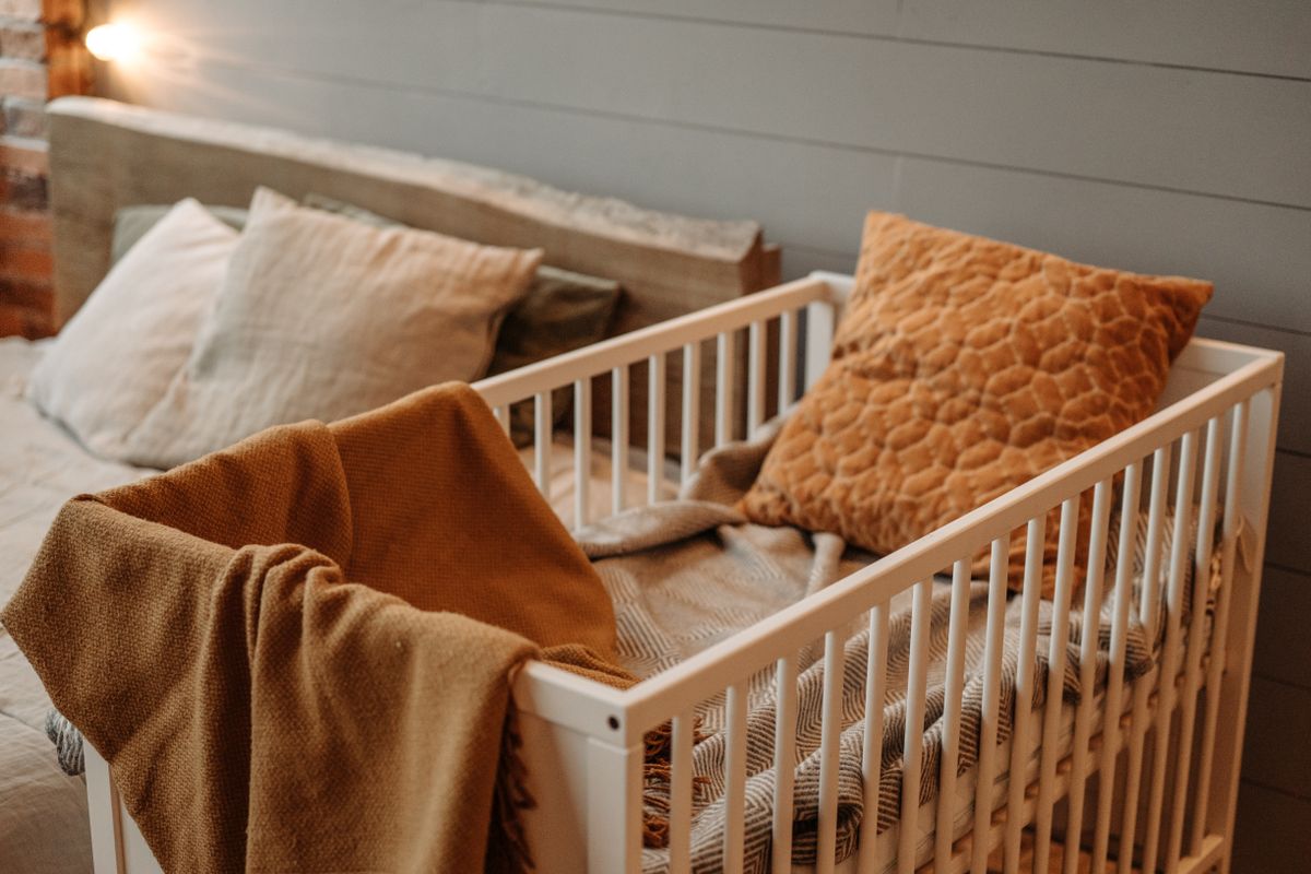 Couffin de bébé placé à côté du lit des parents dans une chambre calme et tamisée