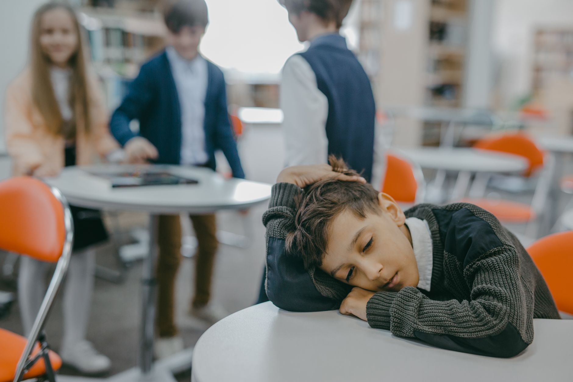 Enfant triste assis seul dans la cour d'école