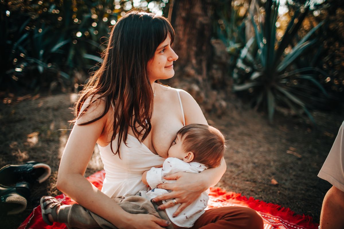 Mère tenant tendrement son bébé dans ses bras, moment de complicité et de transition