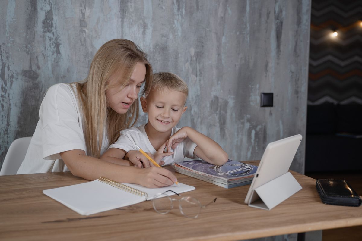 Enfant travaillant avec un tuteur à domicile sur ses devoirs de mathématiques