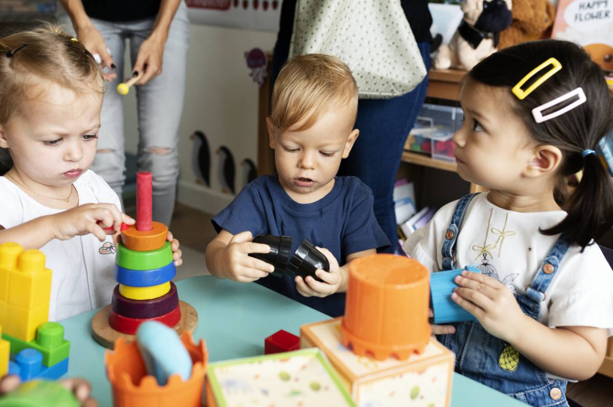 Enfants en crèche autour d'une table de jeux